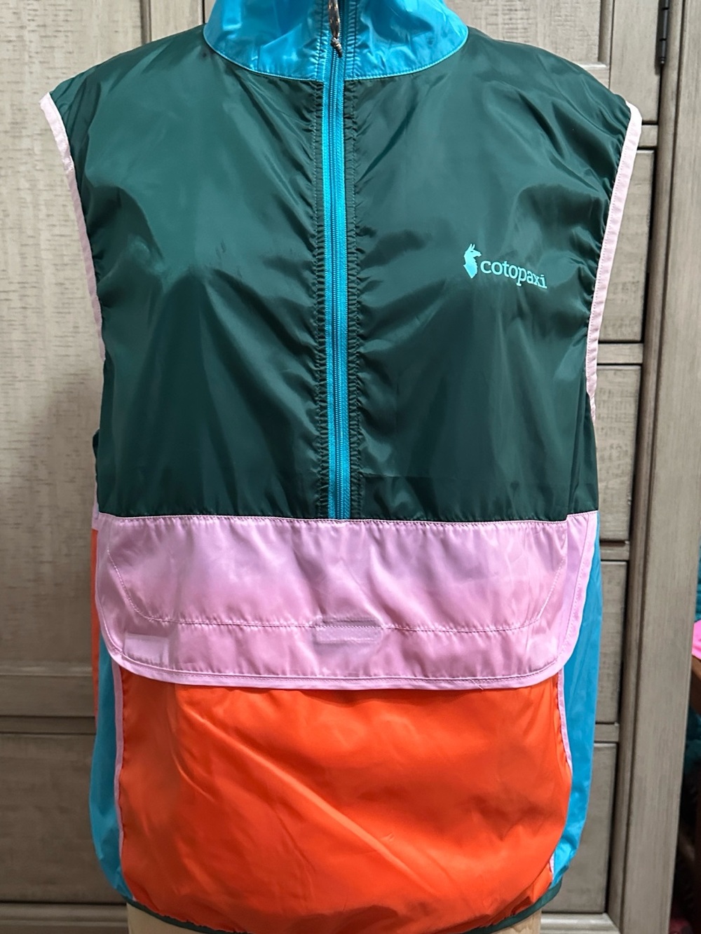 cotopaxi teal green, pink & orange packable vest-style bag